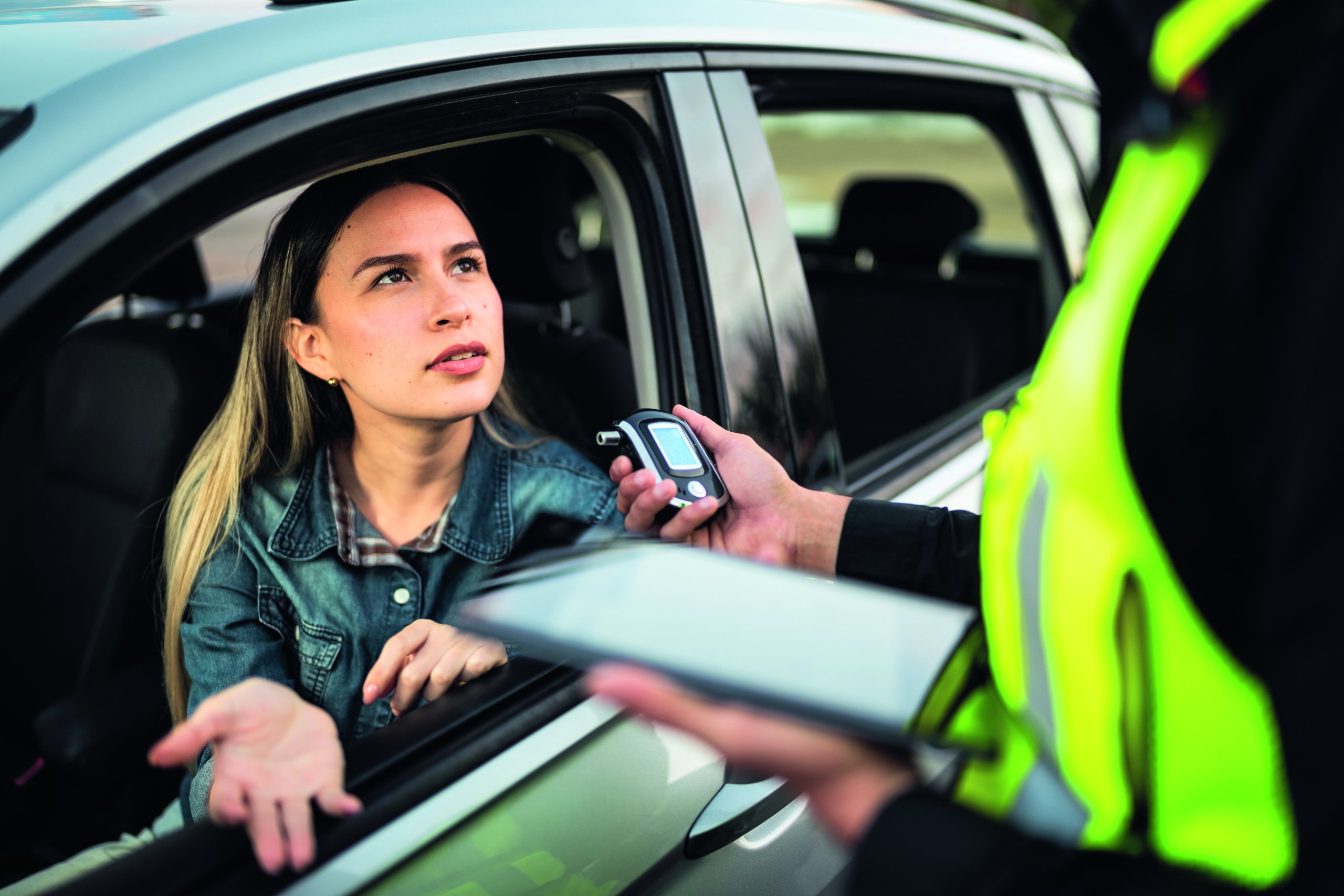 Young woman doing driver alcohol test on street